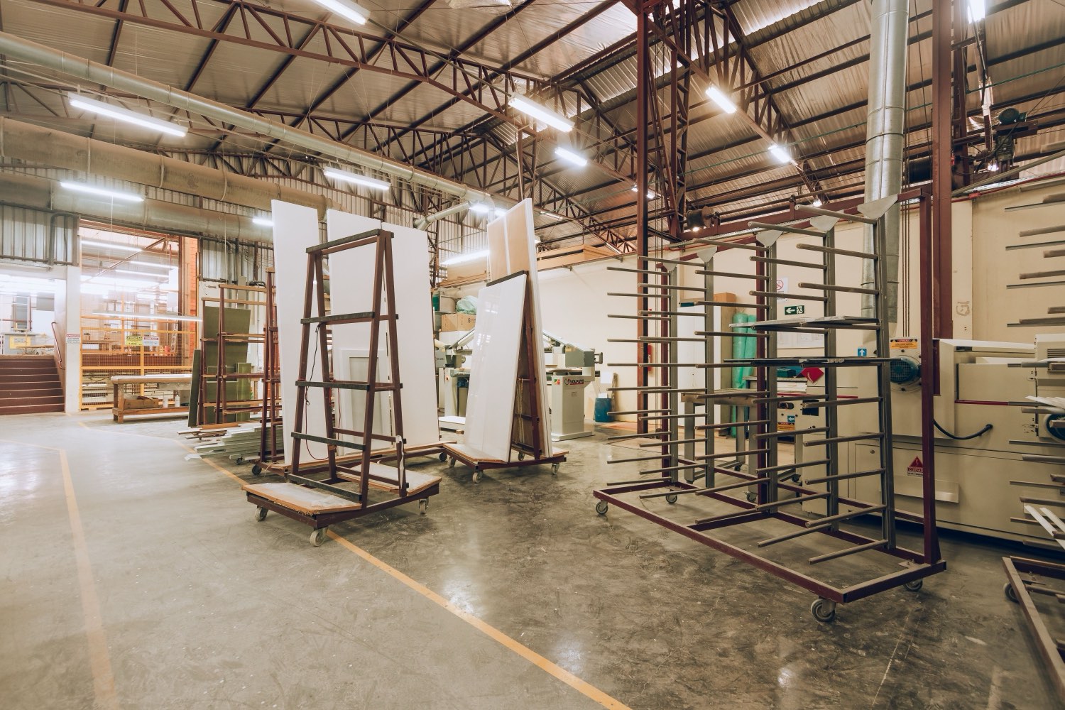 Architectural glass fabrication floor — lites racked for edging, temper and layup